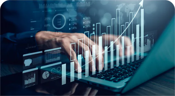 Hands on a laptop with rising sales charts and analytics