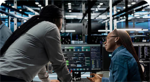 Engineers working together at monitoring screens in a datacenter