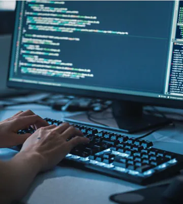 Developer typing code on a backlit keyboard